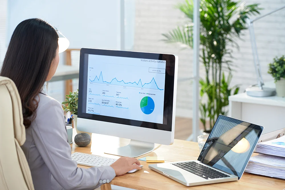 Asian Businesswoman Sitting Desk Office Studying Graphs Large Computer Screen